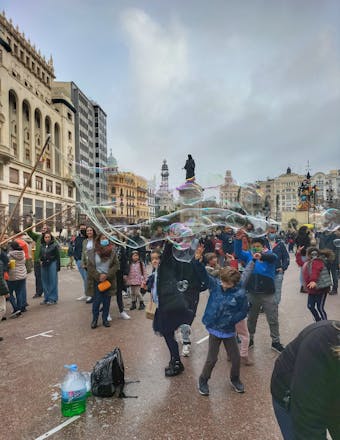Child playing with bubbles in front of Valencia City Hall