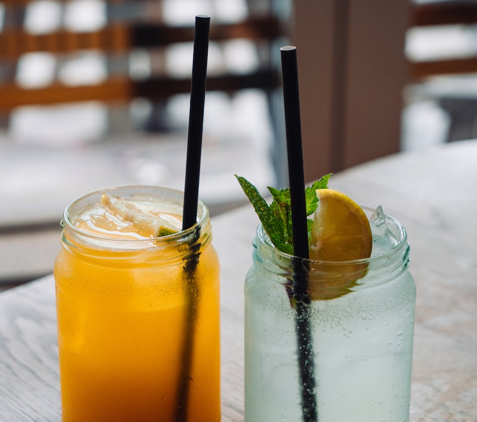 closeup of mason jar glasses with black straws and tonics aka witches brew or winter cold prevention
