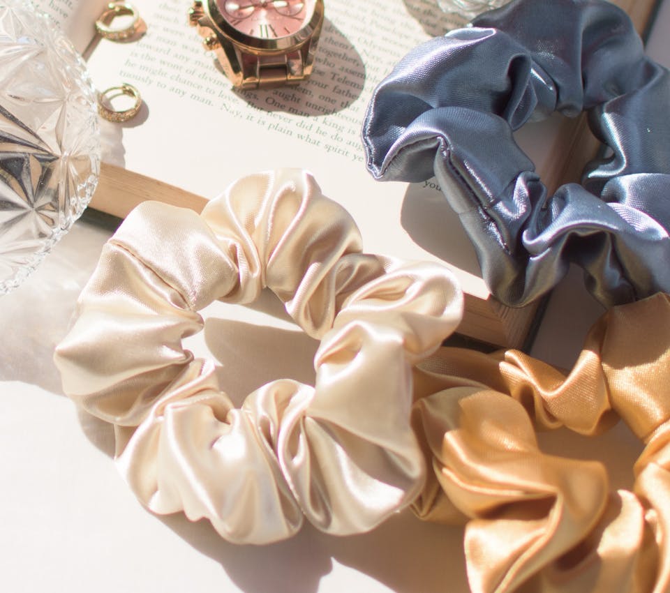 white blue and gold silk scrunchies on white desk