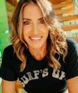 Headshot of Founder of Caliray Wende Zomnir smiling and sitting on stairs