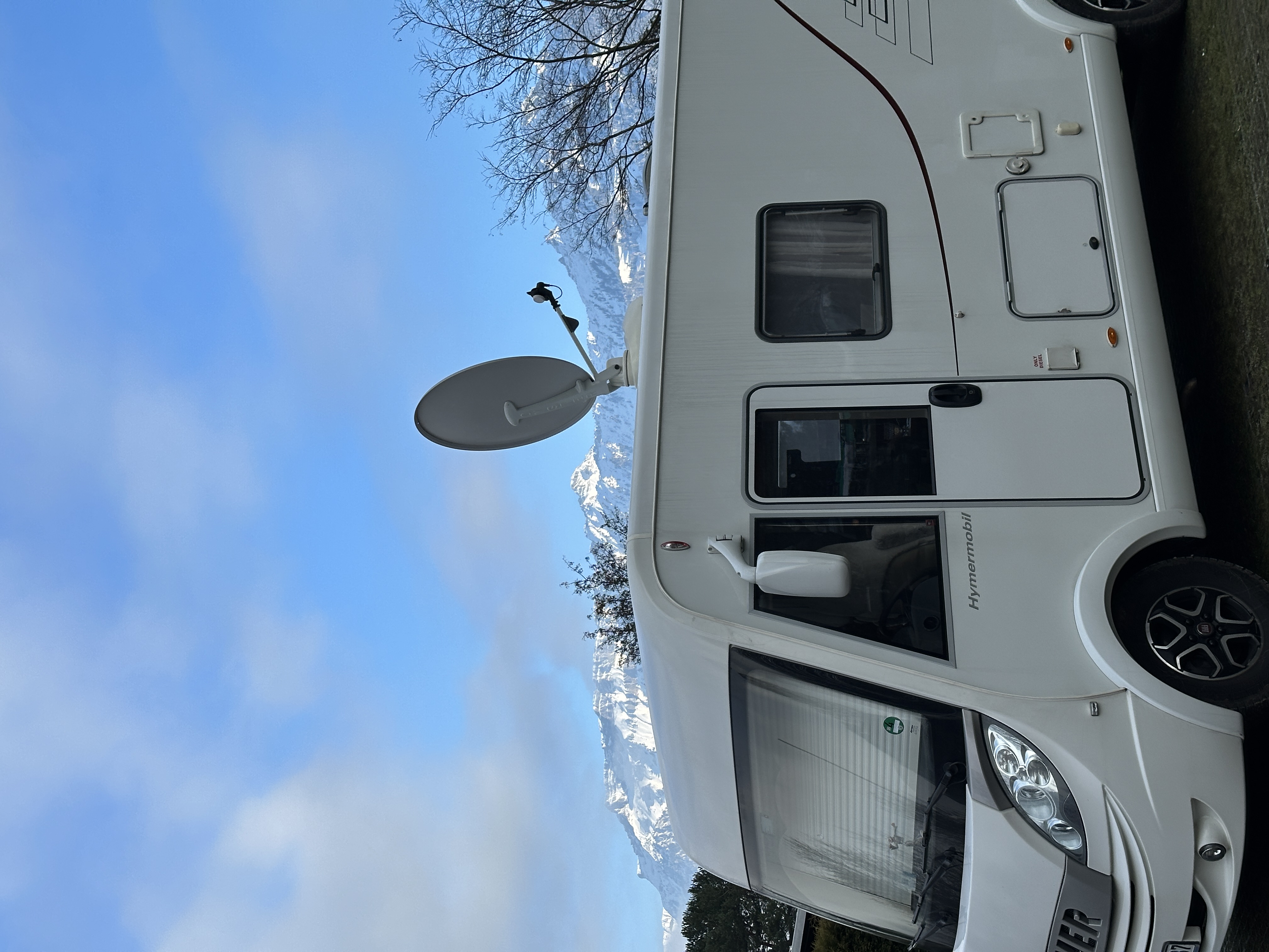 Camper auf Wintersaisonplatz mit Bergen im Hintergrund