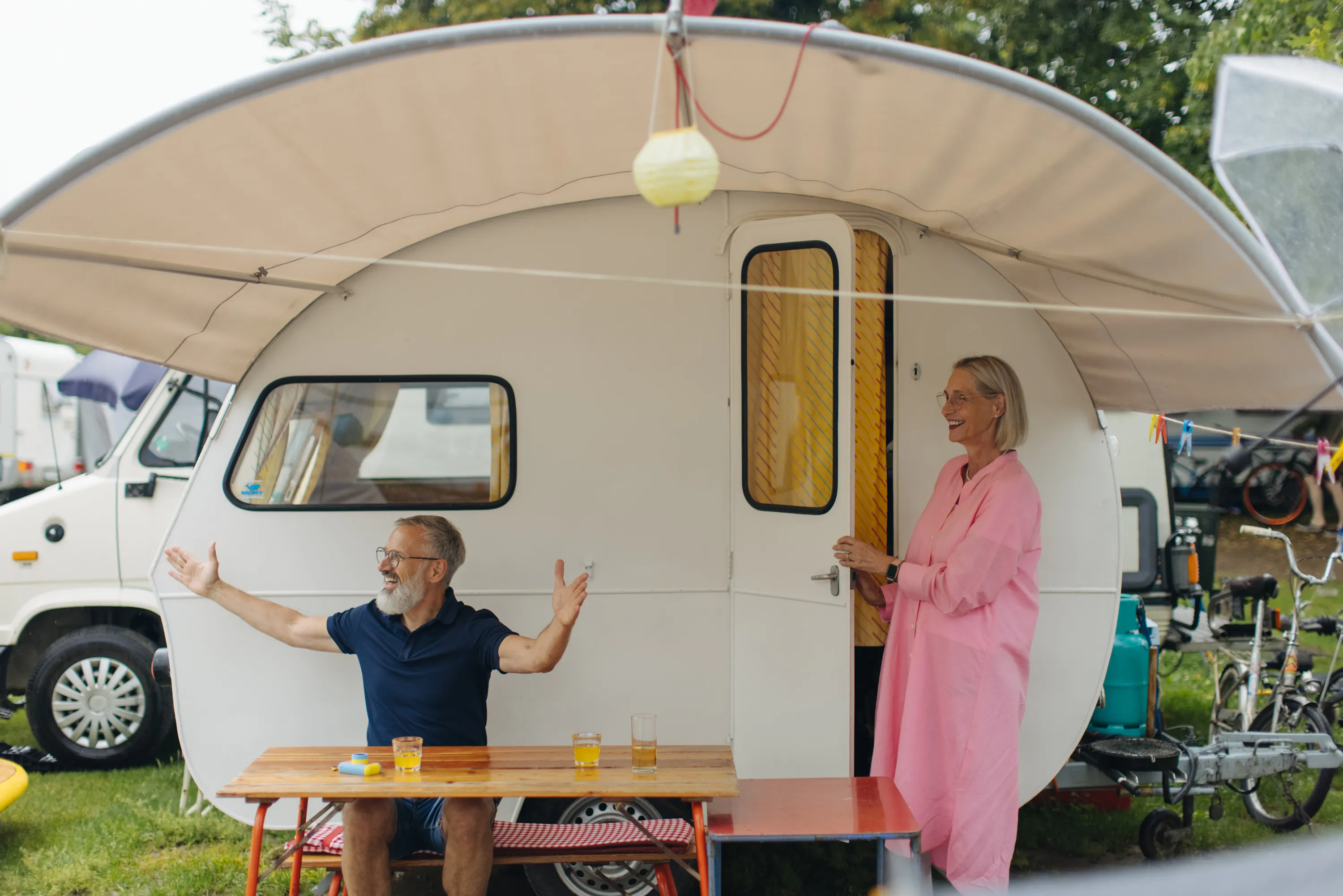 Älteres Paar auf Stellplatz mit Wohnwagen
