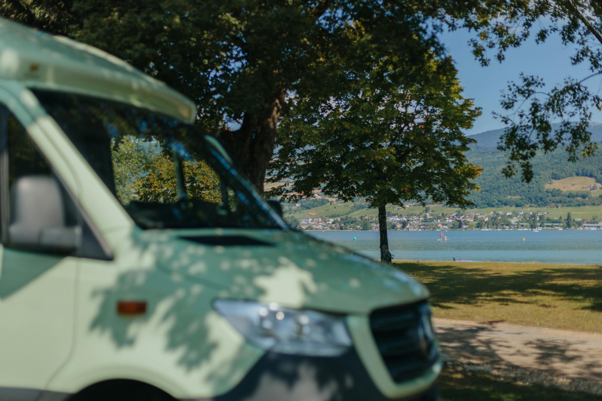 Kastenwagen im Vordergrund unscharf mit Bielersee im Hintergrund