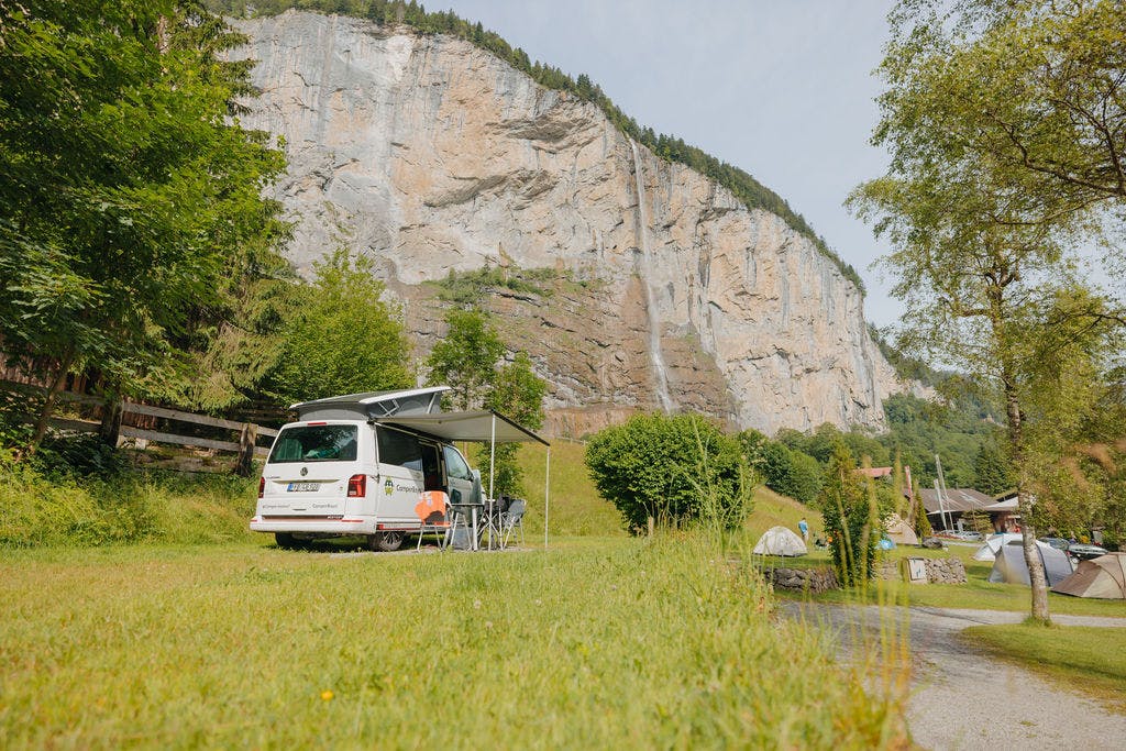 Campervan auf Stellplatz Camping Jungfrau mit Staubbachfall im Hintergrund