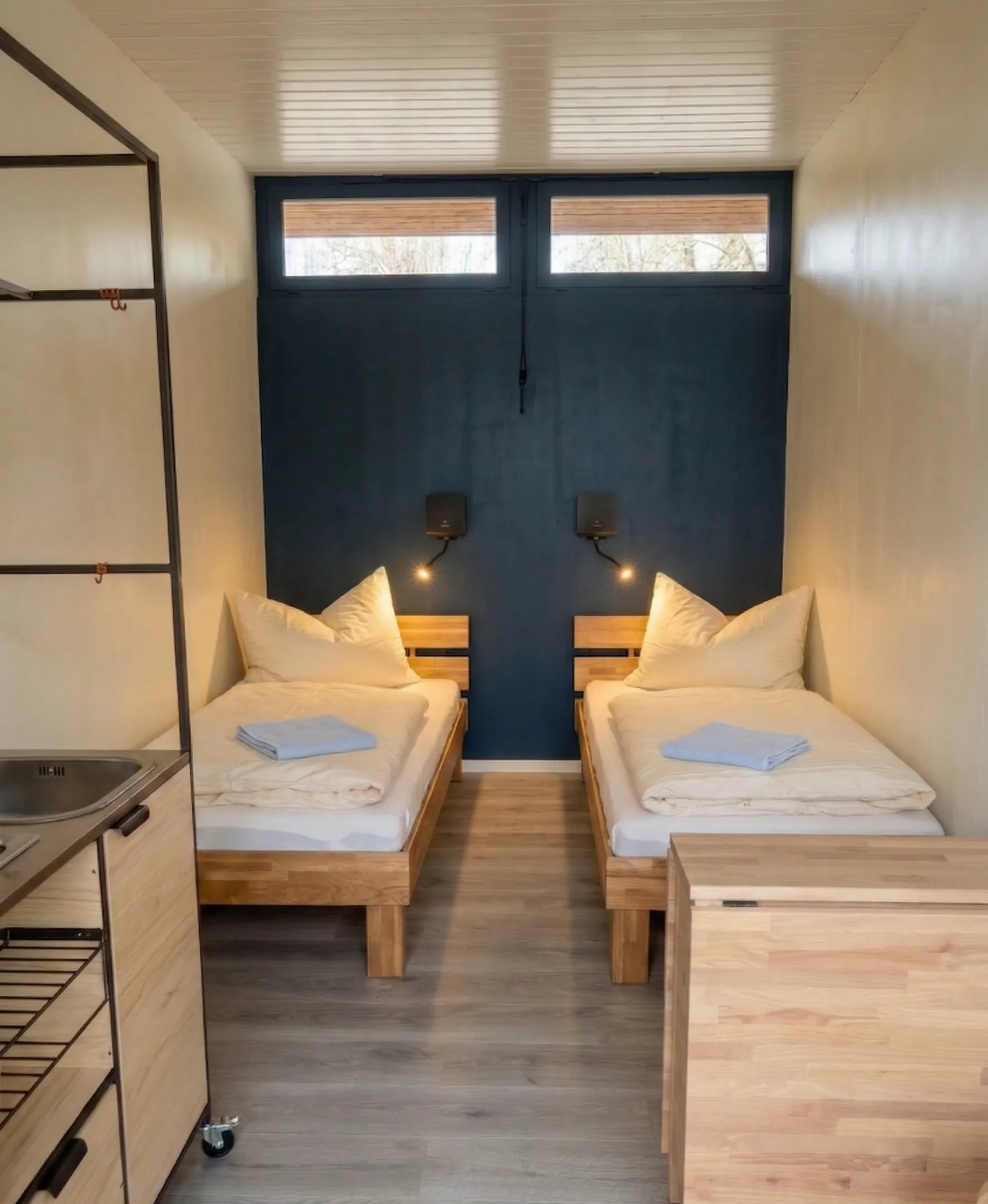 Unterkunft Le Nook auf dem Camping Lausanne mit zwei Betten und kleinem aufklappbaren Tisch