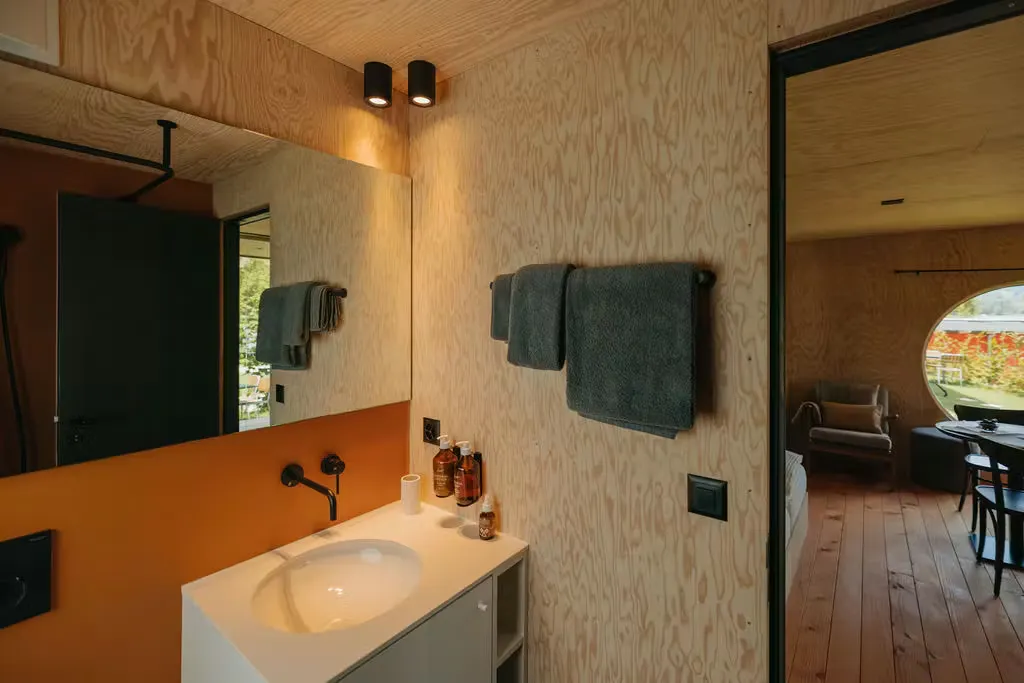 Badezimmer der Mietunterkunft mit Waschbecken, Handtüchern und einem Spiegel