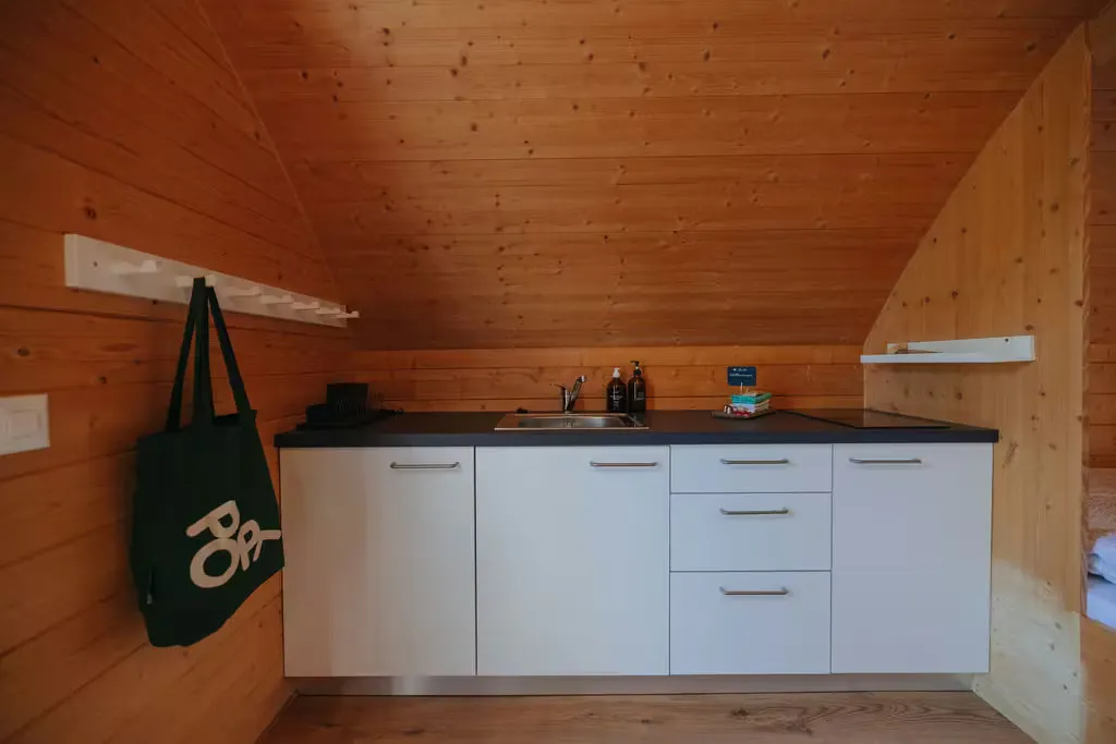 Küchenzeile der Beach Cabin auf Camping Erlach mit Tasche an der Wand