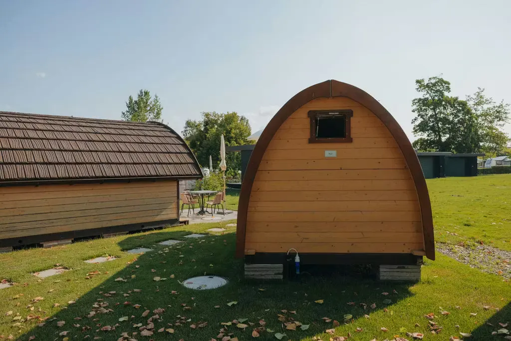 Rückseite des Beach Huts auf dem Camping Erlach mit einem kleinen Fenster, einer weiteren Unterkunft nebenan und grünem Gras