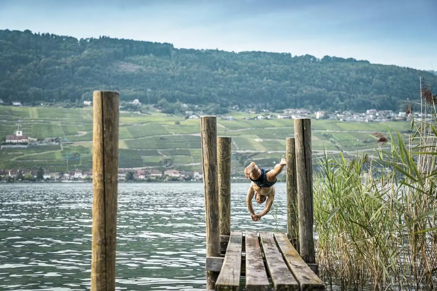 Person springt ins Wasser von einem Steg der St. Peterinsel in den Bielersee
