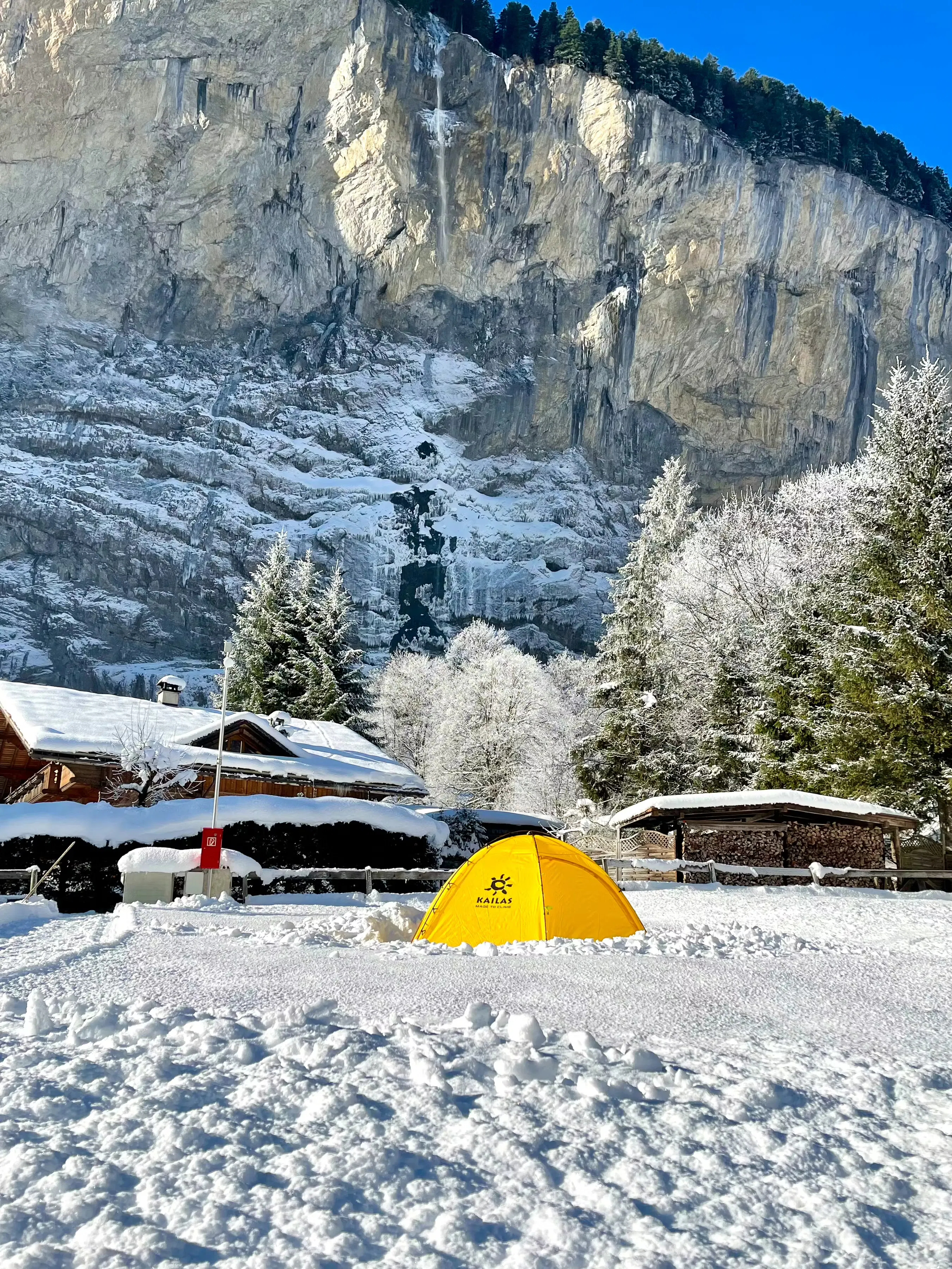 Gelbes Zelt auf einem Zeltplatz auf dem Campingplatz Jungfrau an einem typischen Wintertag im Schnee
