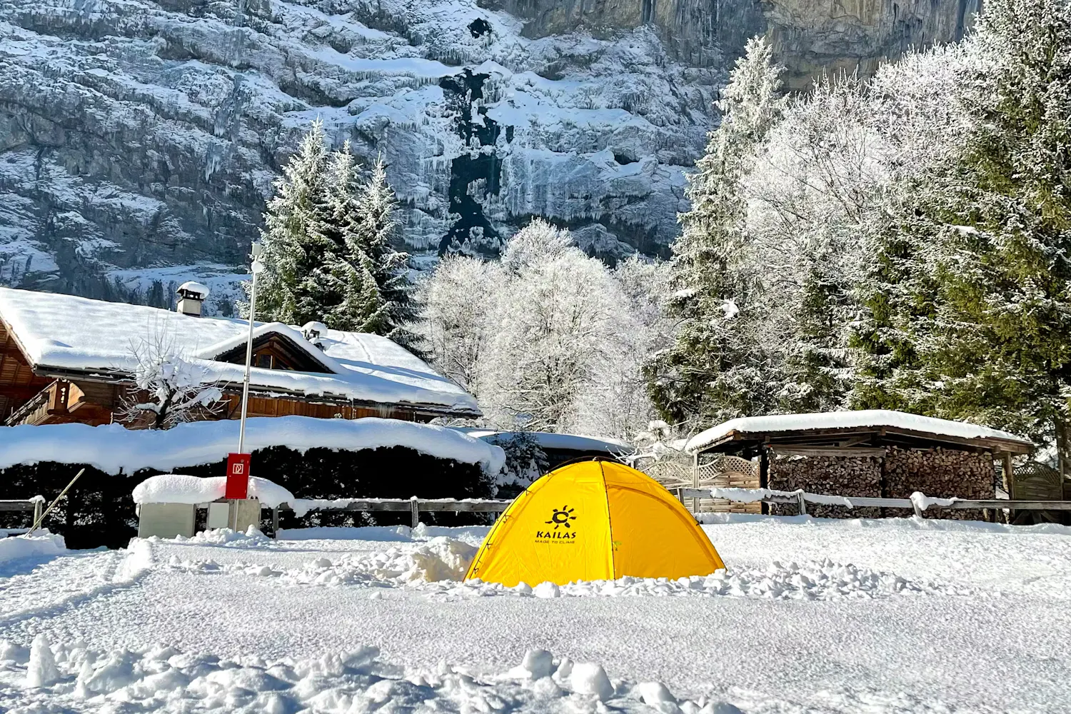 Una tienda amarilla en un camping del Camping Jungfrau en un típico día de invierno nevado