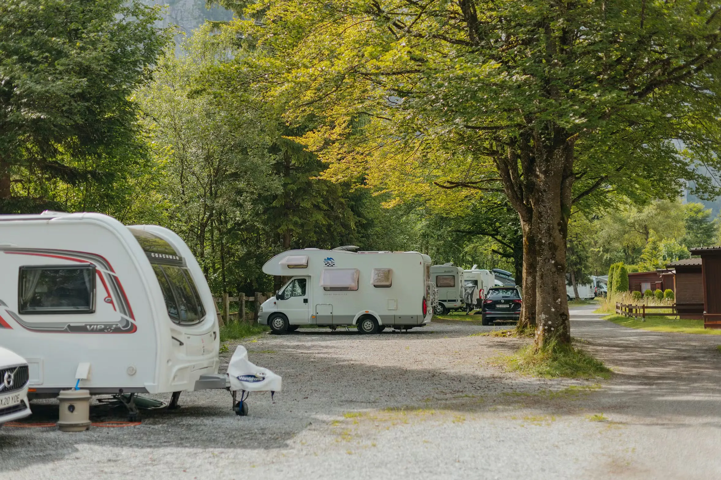 Stellplätze mit Wohnwagen und Bäumen an den Seiten