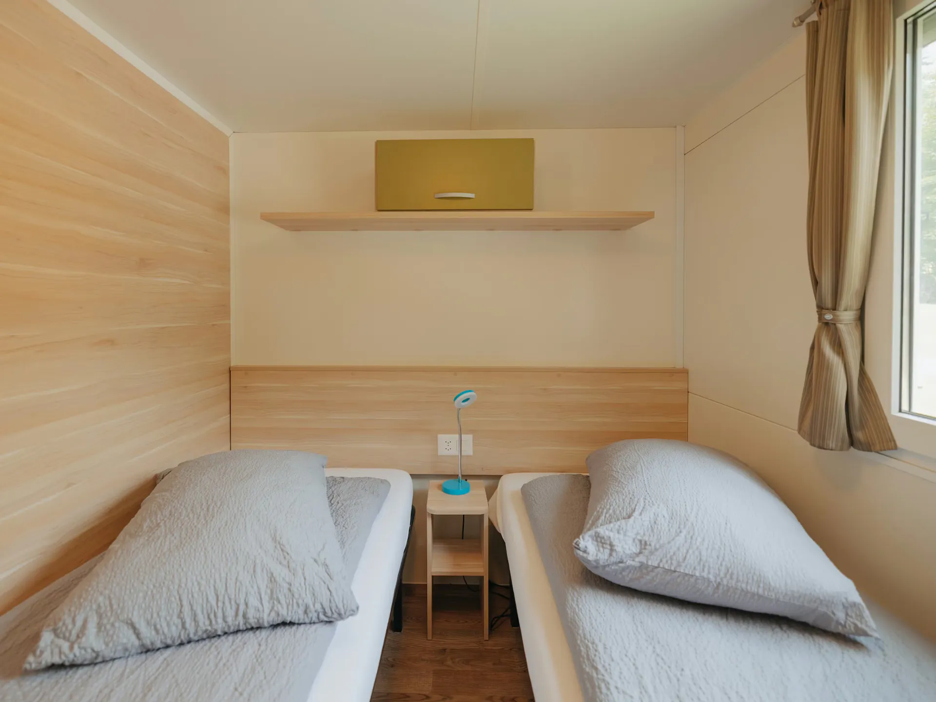 Dormitorio de la casa móvil Staubbach con dos camas individuales y sábanas grises