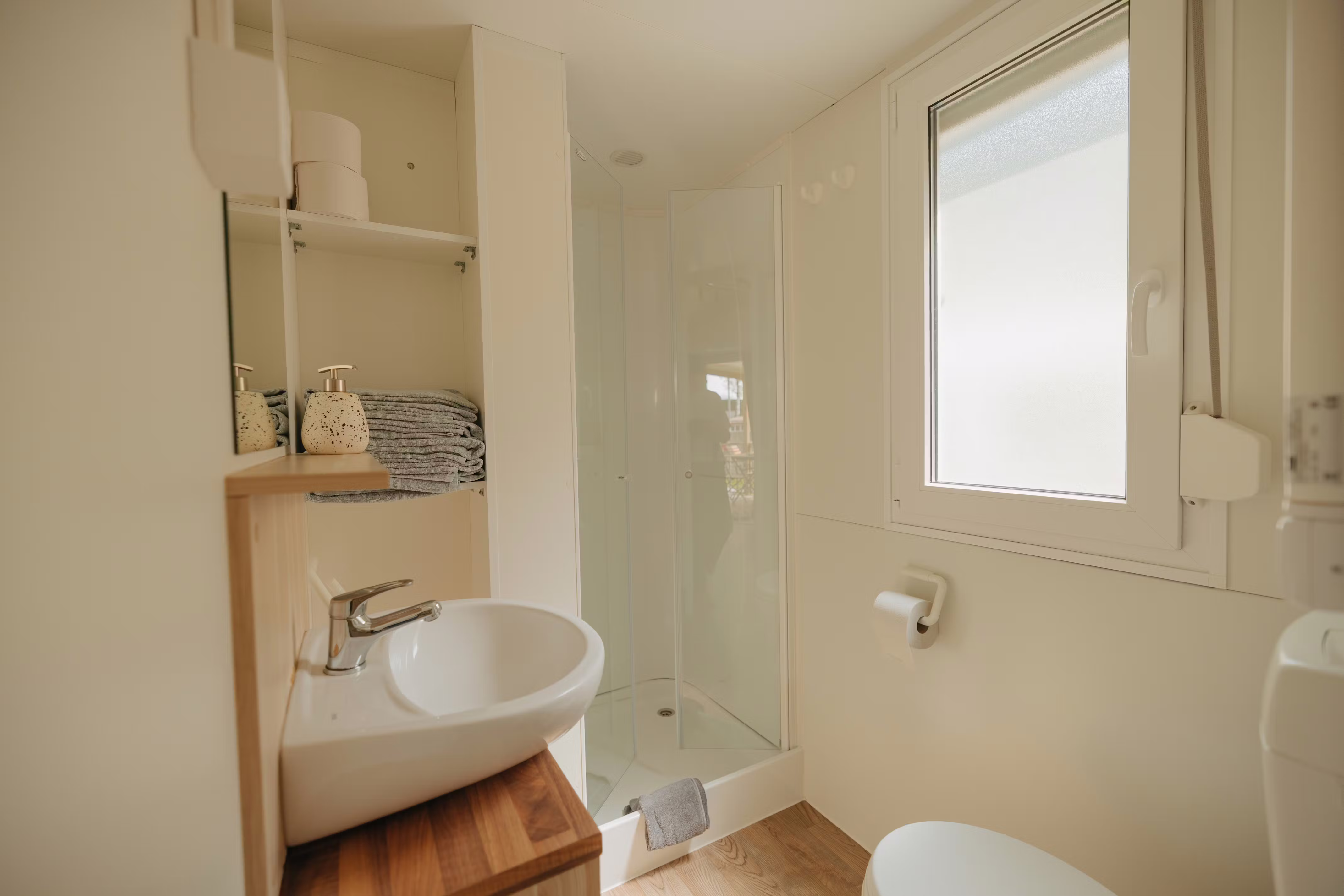 Cuarto de baño de la casa móvil Staubbach en el Camping Jungfrau, con ducha, lavabo y aseo