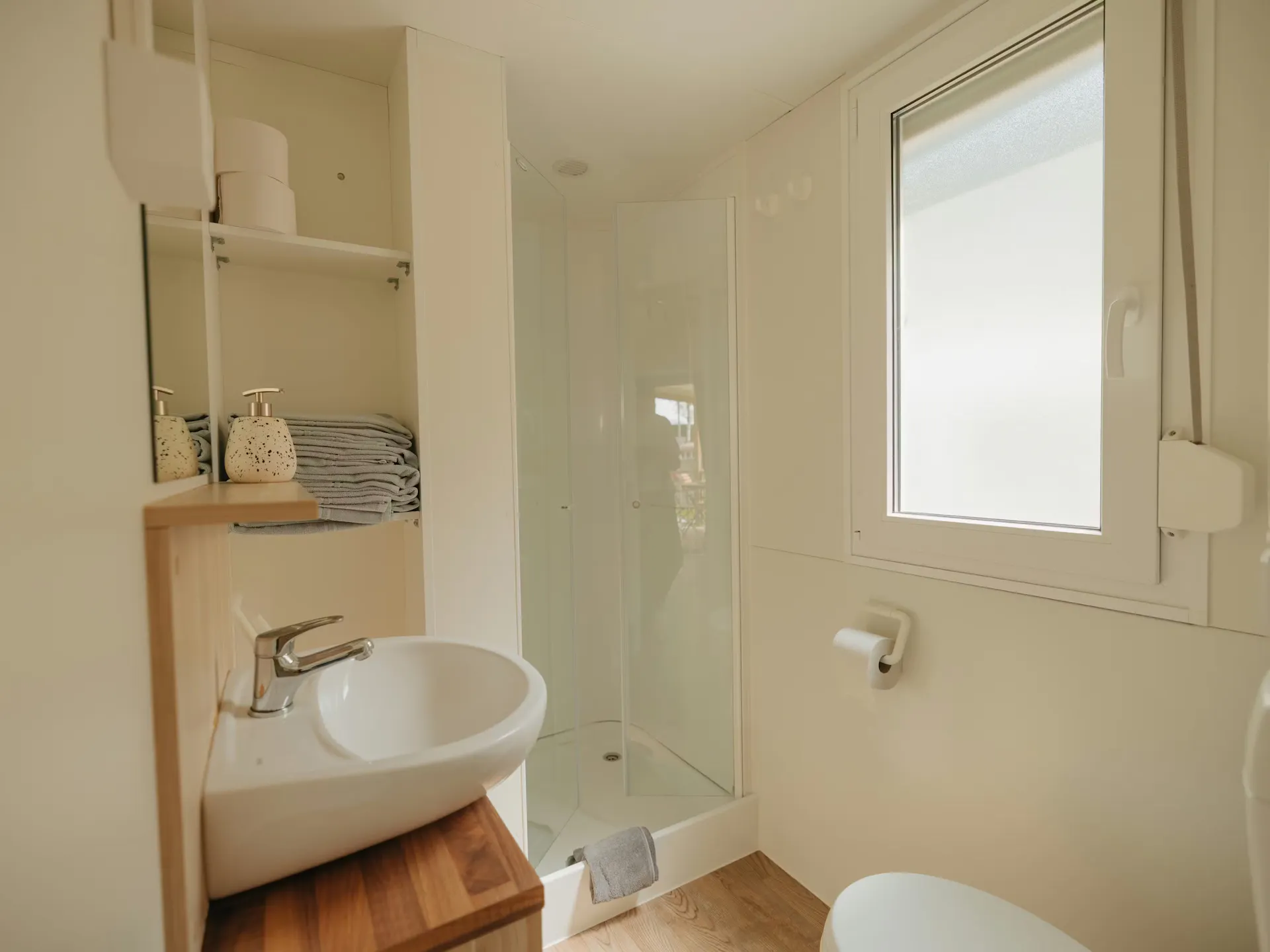 Cuarto de baño de la casa móvil Staubbach en el Camping Jungfrau, con ducha, lavabo y aseo