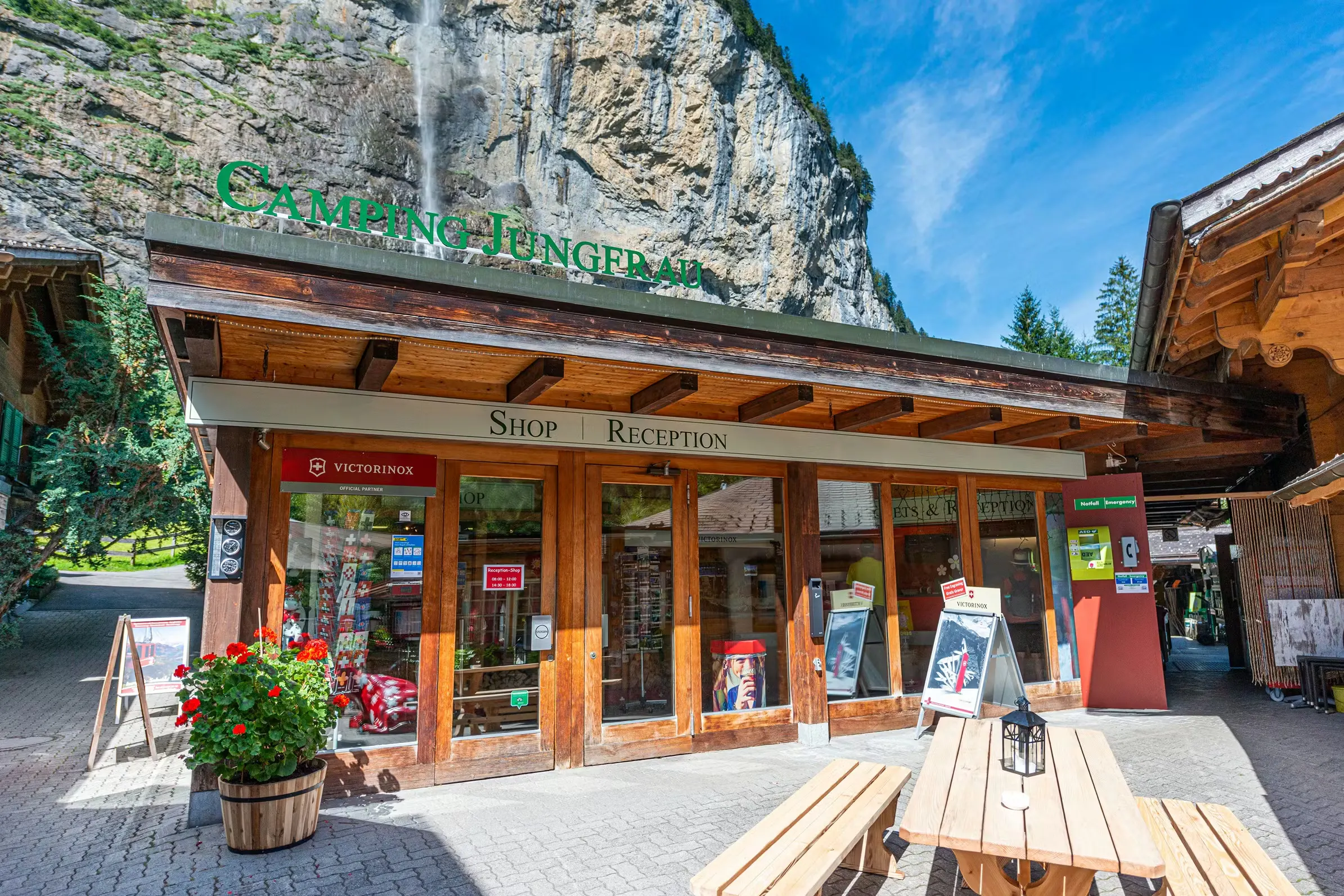Empfang von Camping Jungfrau mit dem Tisch im Vordergrund und dem Staubbach-Wasserfall im Hintergrund