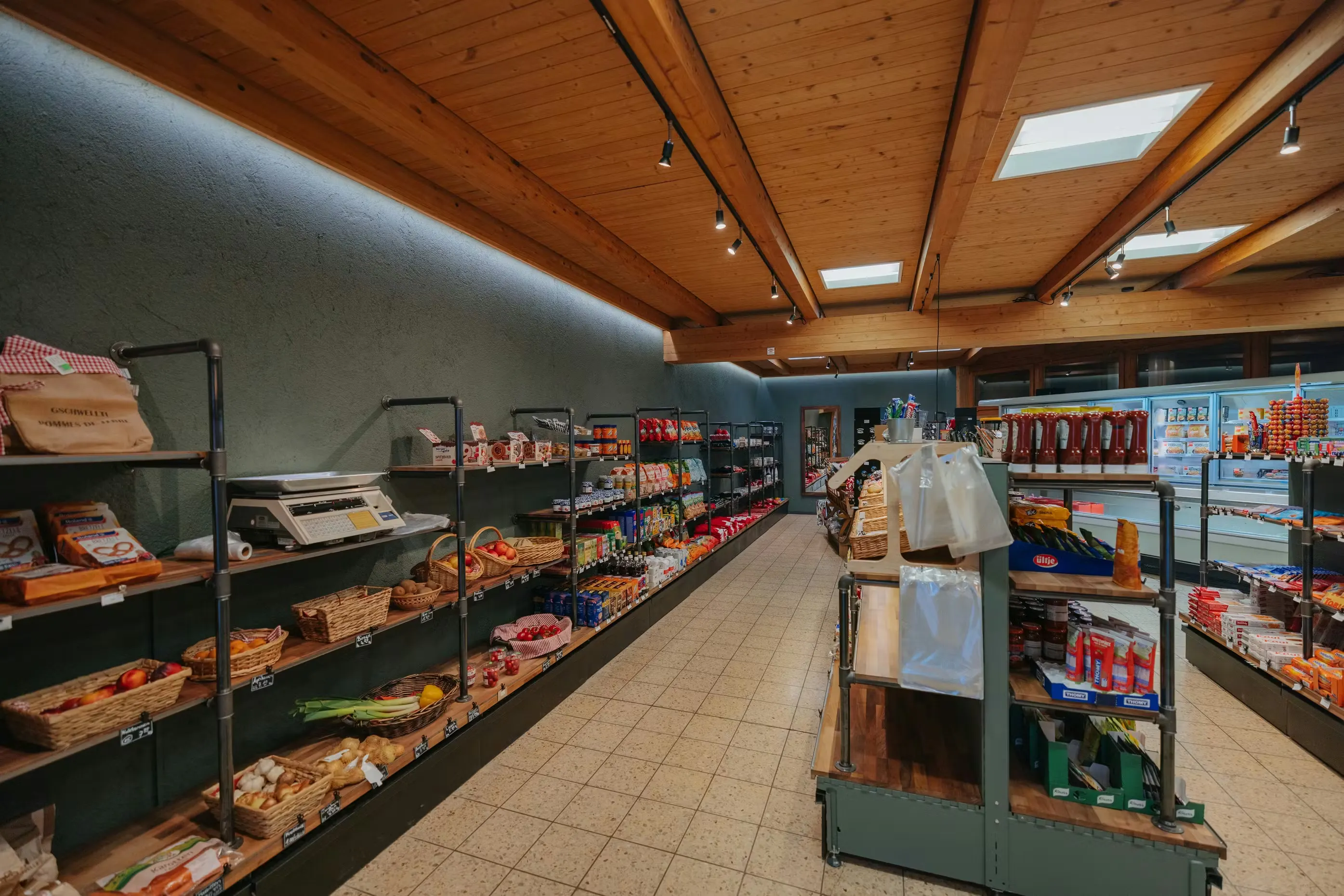 Shop von Camping Jungfrau, Regale gefüllt mit frischem Obst, Brot, Fertiggerichten