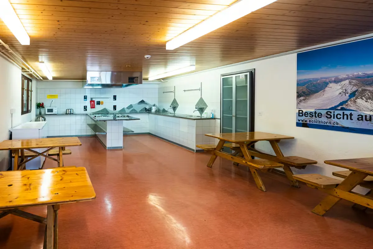Gemeinschaftsküche mit Tischen und Bänken auf dem Camping Jungfrau in Lauterbrunnen