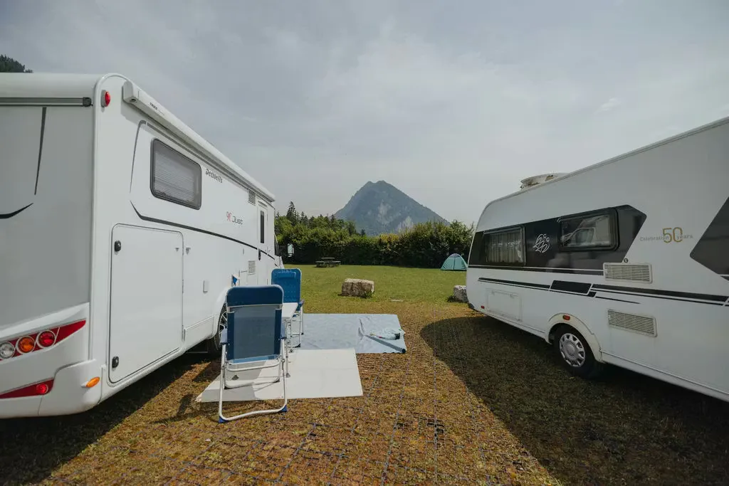 Wohnmobil und Wohnwagen auf dem Prestige Stellplatz mit Blick Richtung Berge