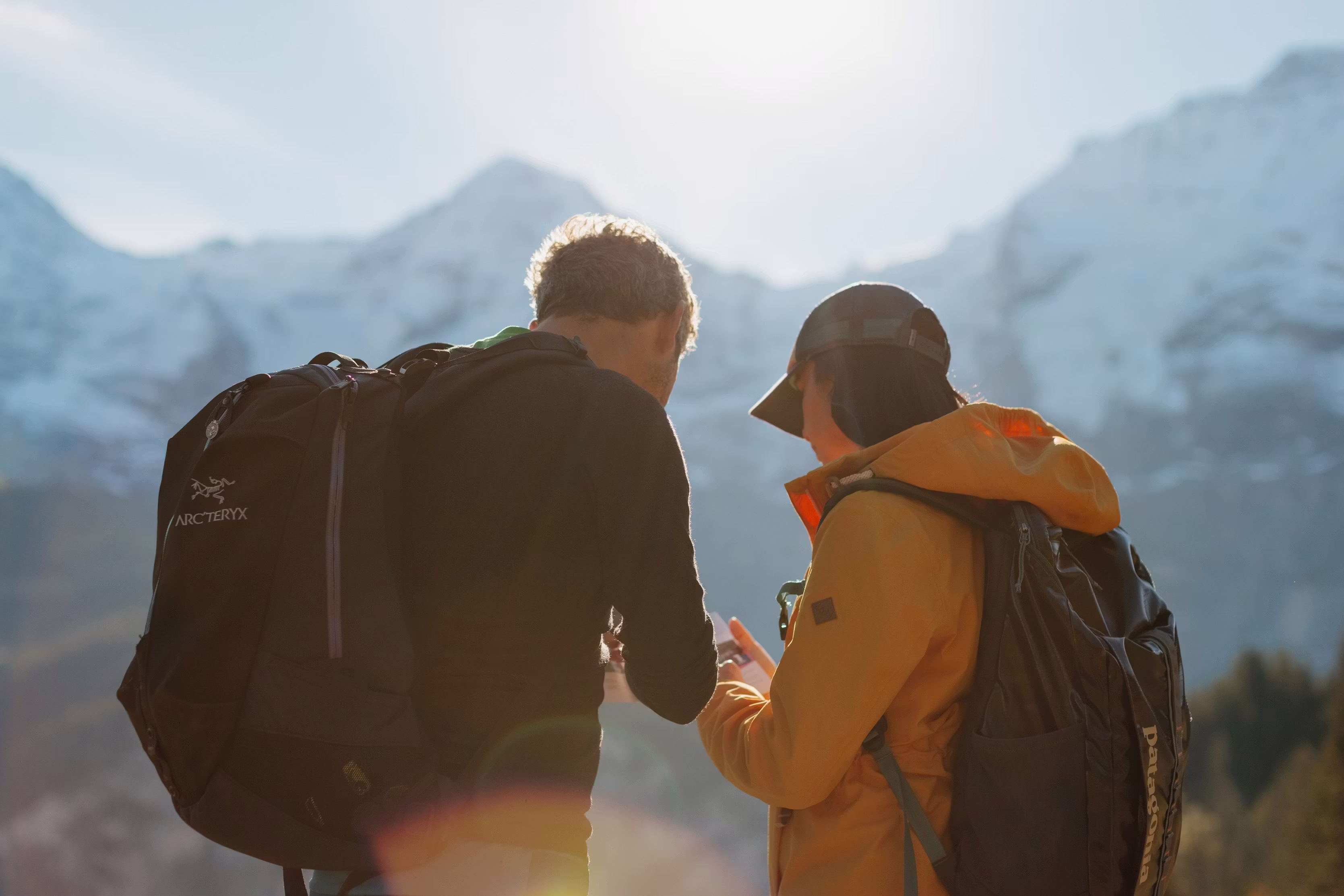 Wanderer mit Blick auf eine Karte mit den Bergen Eiger, Mönch und Jungfrau im Hintergrund