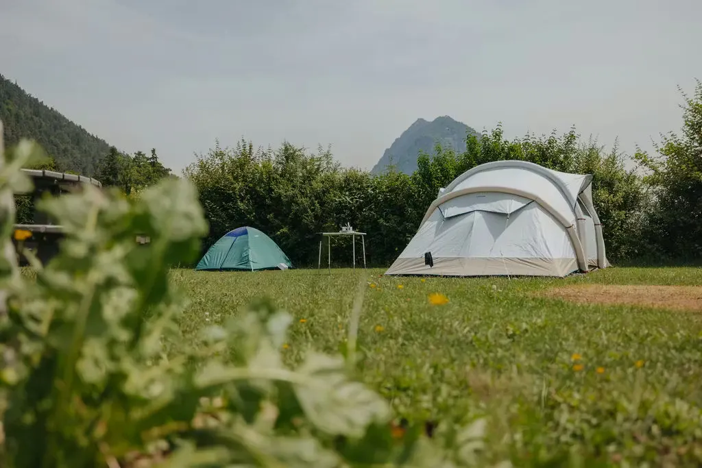 ein kleines und ein grosses Zelt auf dem Zeltplatz auf der grünen Wiese auf dem Campingplatz Alpenblick