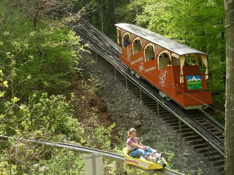 Drahtseilbahn im Hintergrund mit Rodlerin im Vordergrund