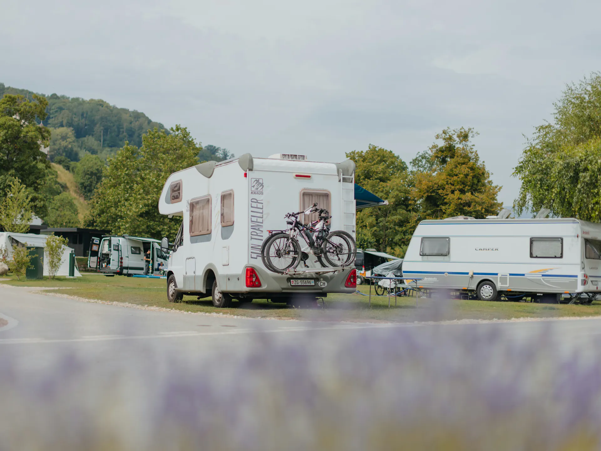 Wohnmobil auf einem Komfort Stellplatz am See, neben einem Wohnwagen