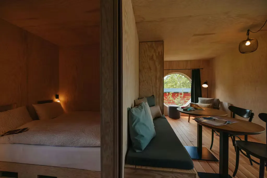 Doppelbett und Wohnzimmer der Beach Lodge auf dem Campingplatz Erlach