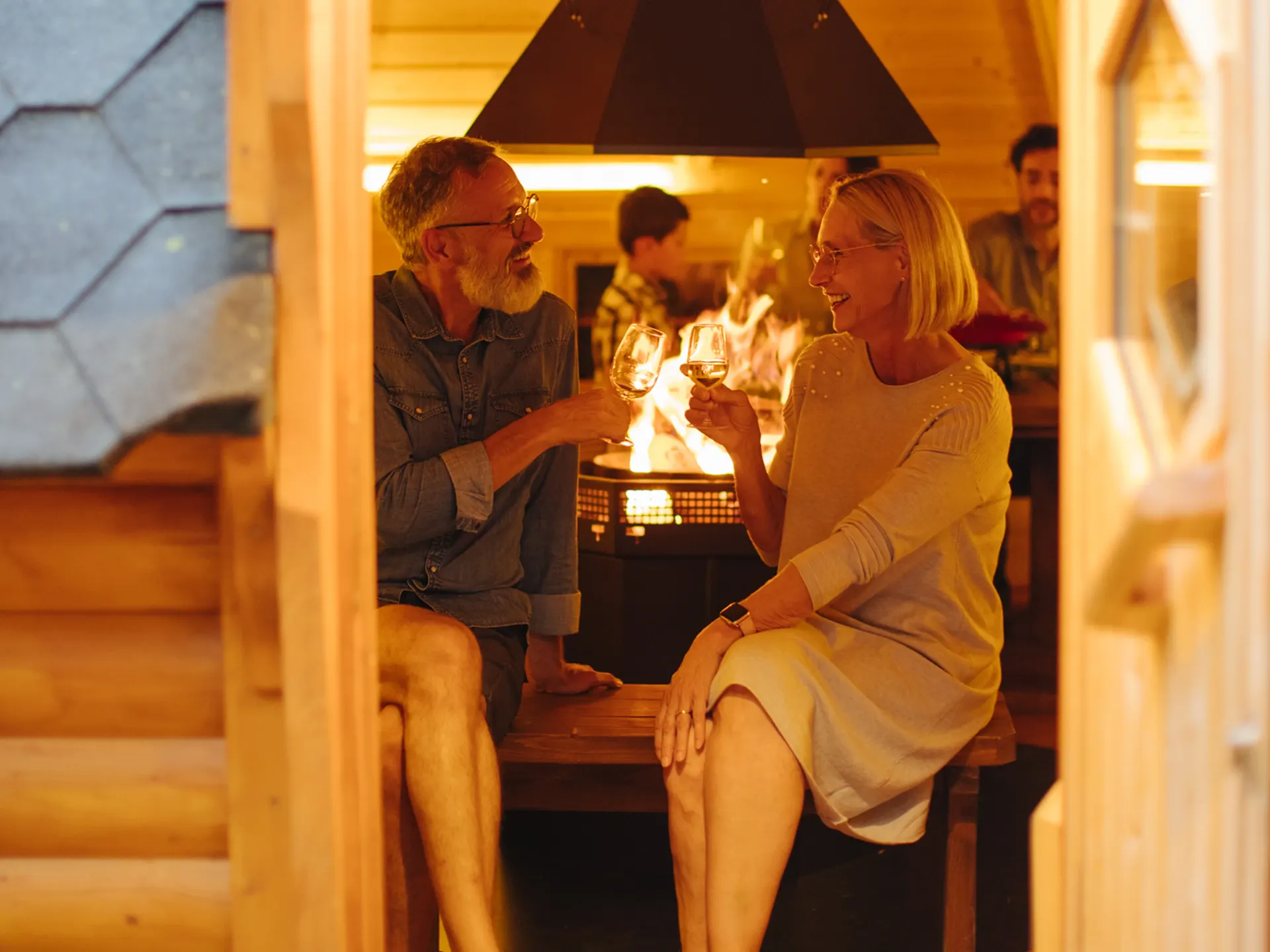 Zwei Personen mit Weinglas im Grillhaus Woodstöckli Camping Alpenblick Unterseen Interlaken