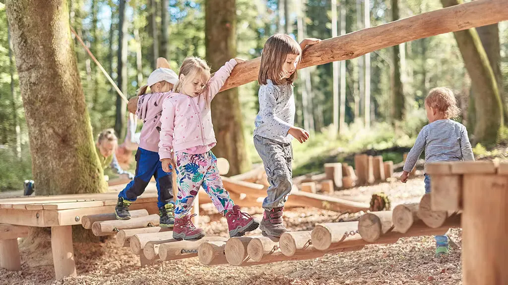 Kinder auf einer Holzbrücke auf Kinderwanderweg Ins