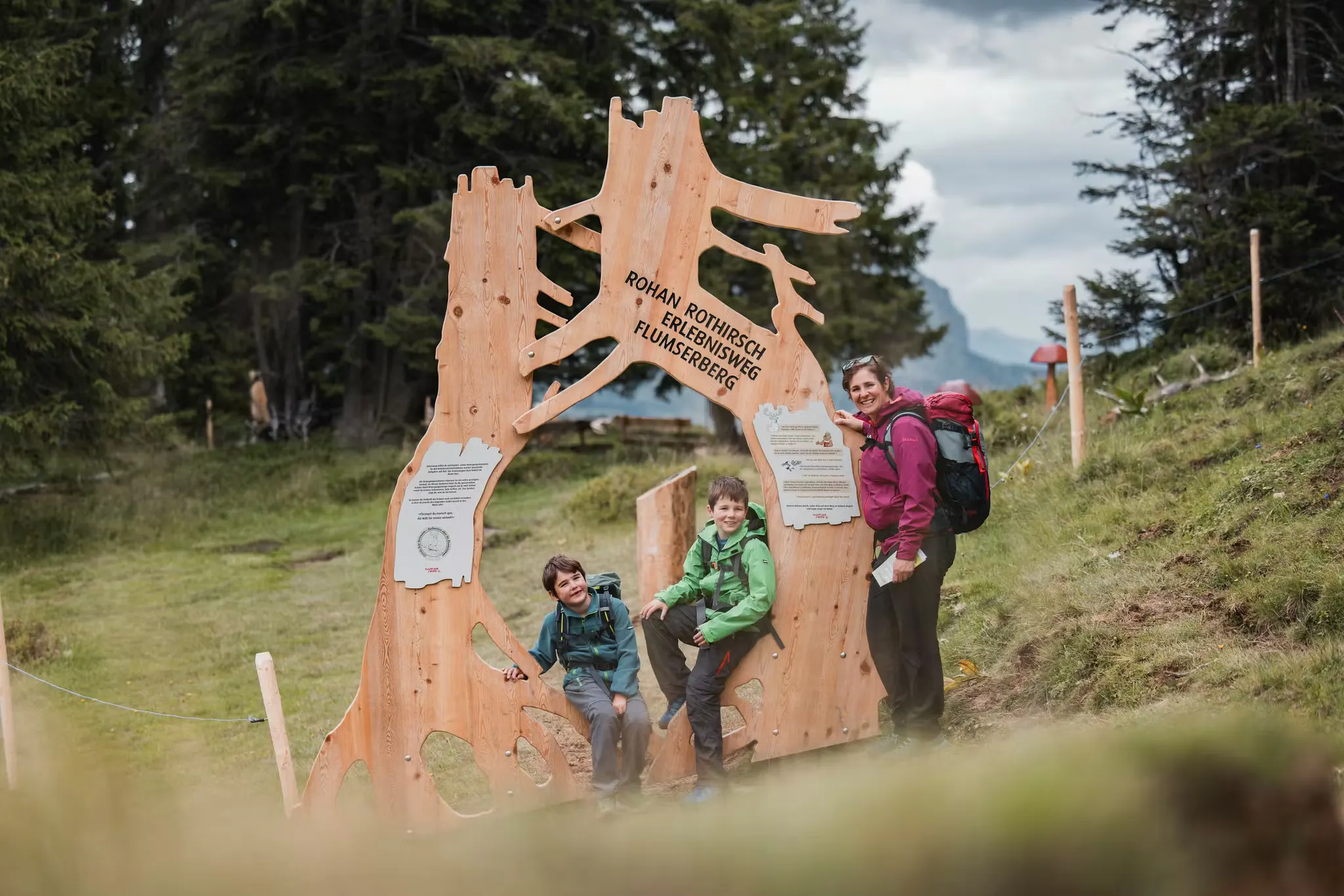 Zwei Kinder und eine Frau auf dem Wander- und Entdeckungspfad auf dem Flumersberg