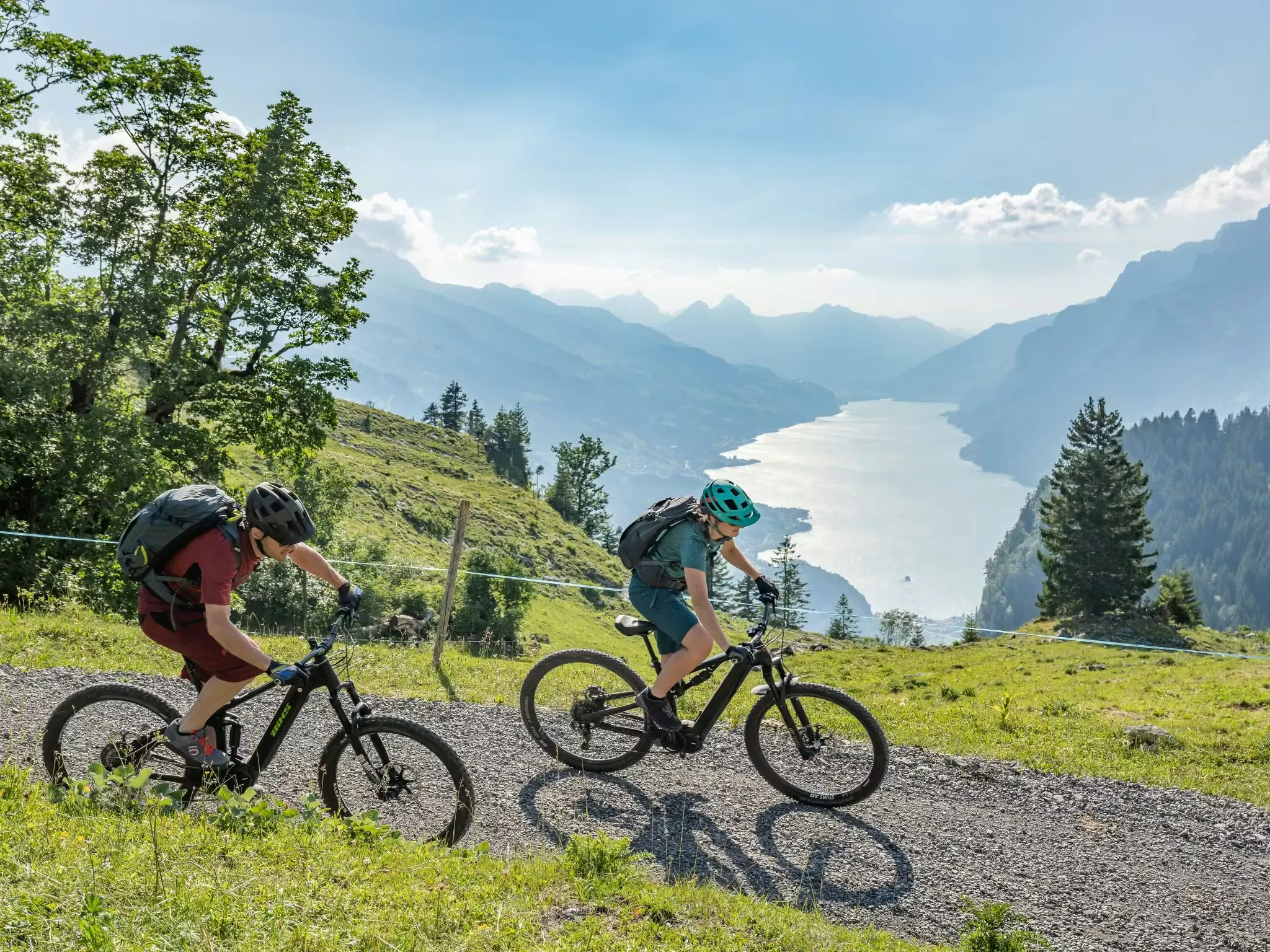 Zwei Mountainbiker auf einem Mountainbike-Weg in den Schweizer Bergen mit Blick auf den Walensee