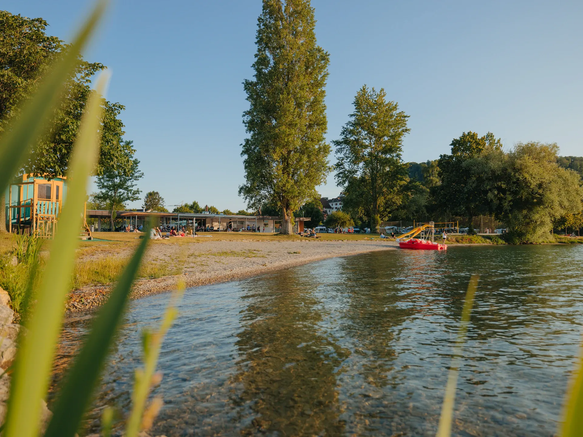 Blick auf Bielersee Ufer, Strandwiese und Hauptgebäude des Camping Erlach