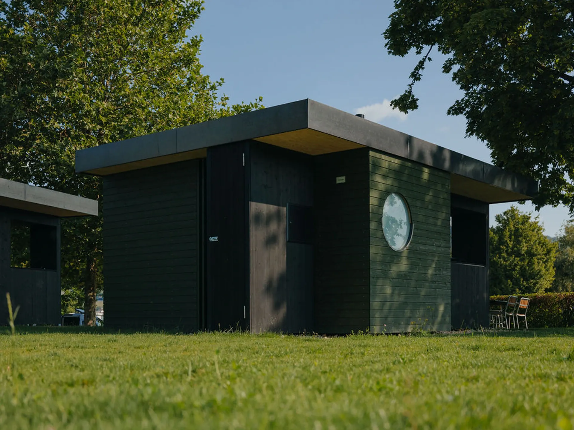 Mietunterkunft Beach Cottage von hinten mit grünem Gras drumherum