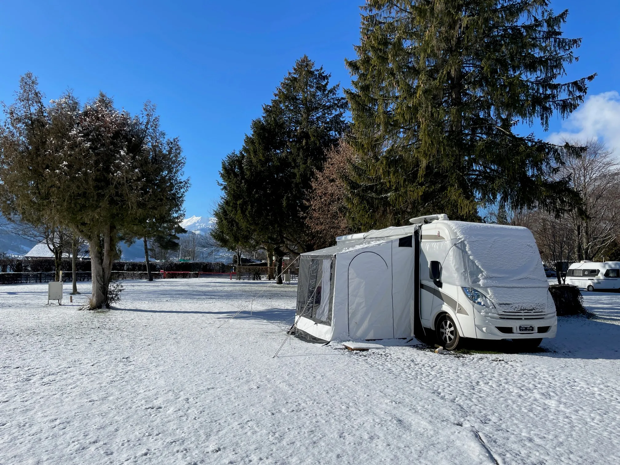 schneebedeckter Camper auf Winterstellplatz im Camping Alpenblick in Interlaken