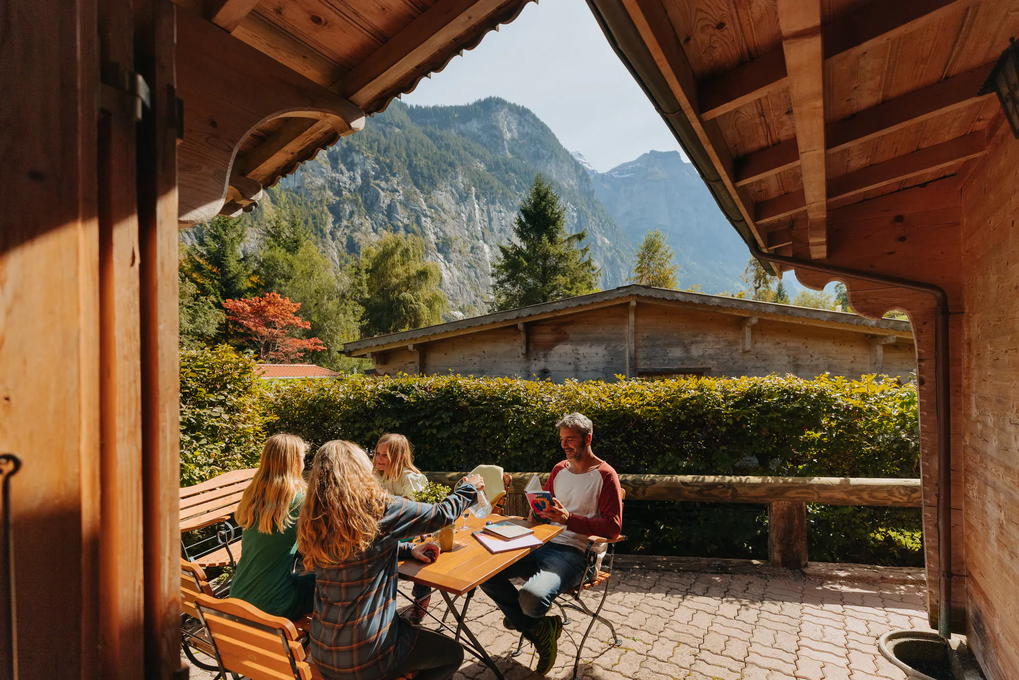 Familie sitzt auf Terrasse des Bungalow auf dem Camping Jungfrau