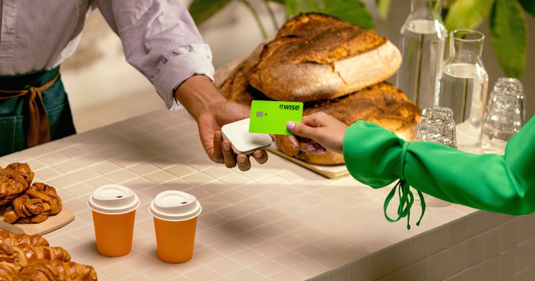 Woman paying for coffee using a Wise card.