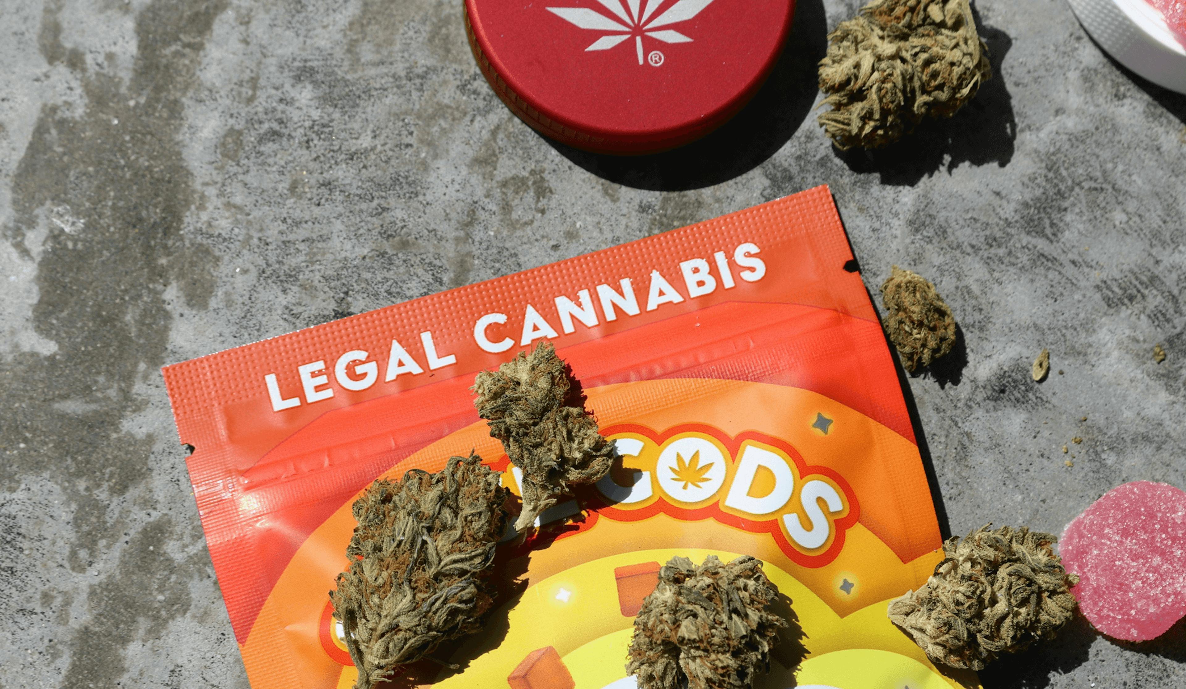 Legal cannabis buds and infused edibles on colorful packaging labeled 'Legal Cannabis Gummies