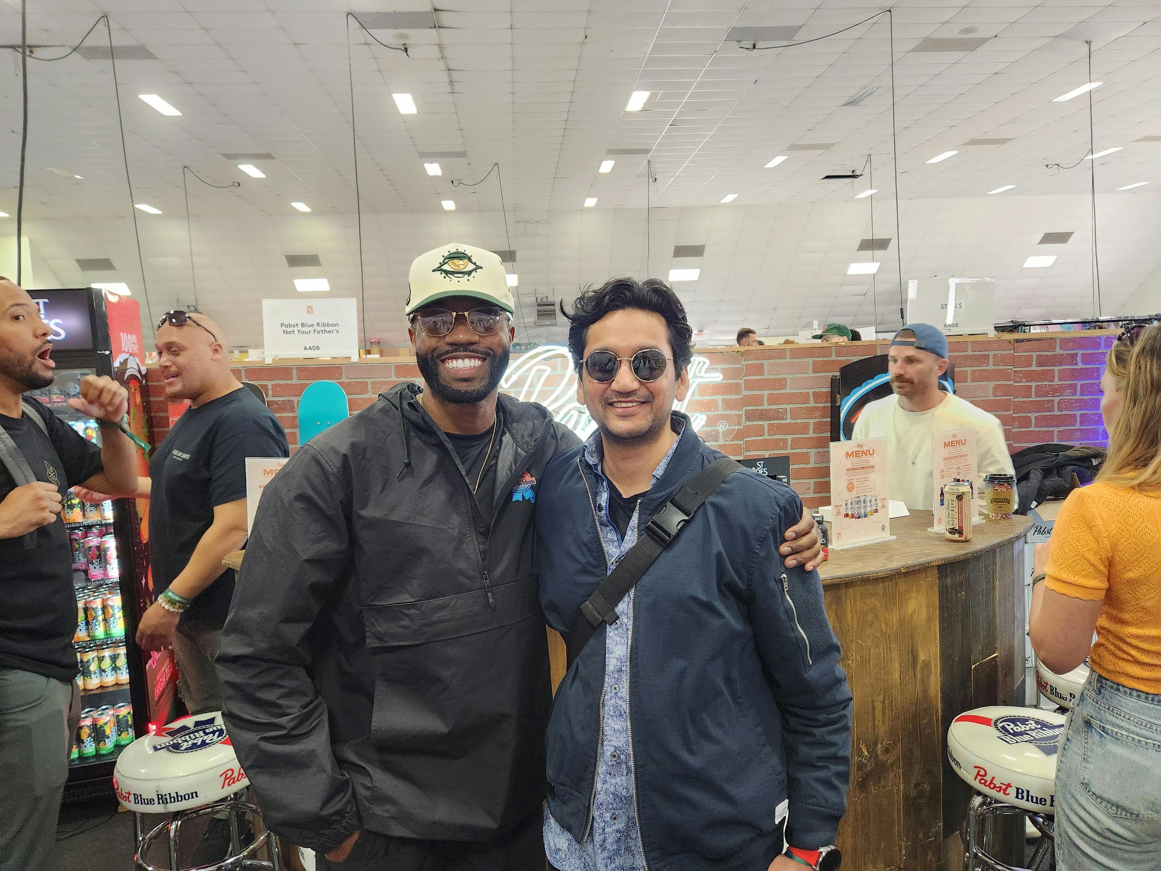 Two smiling individuals posing at a cannabis industry event.