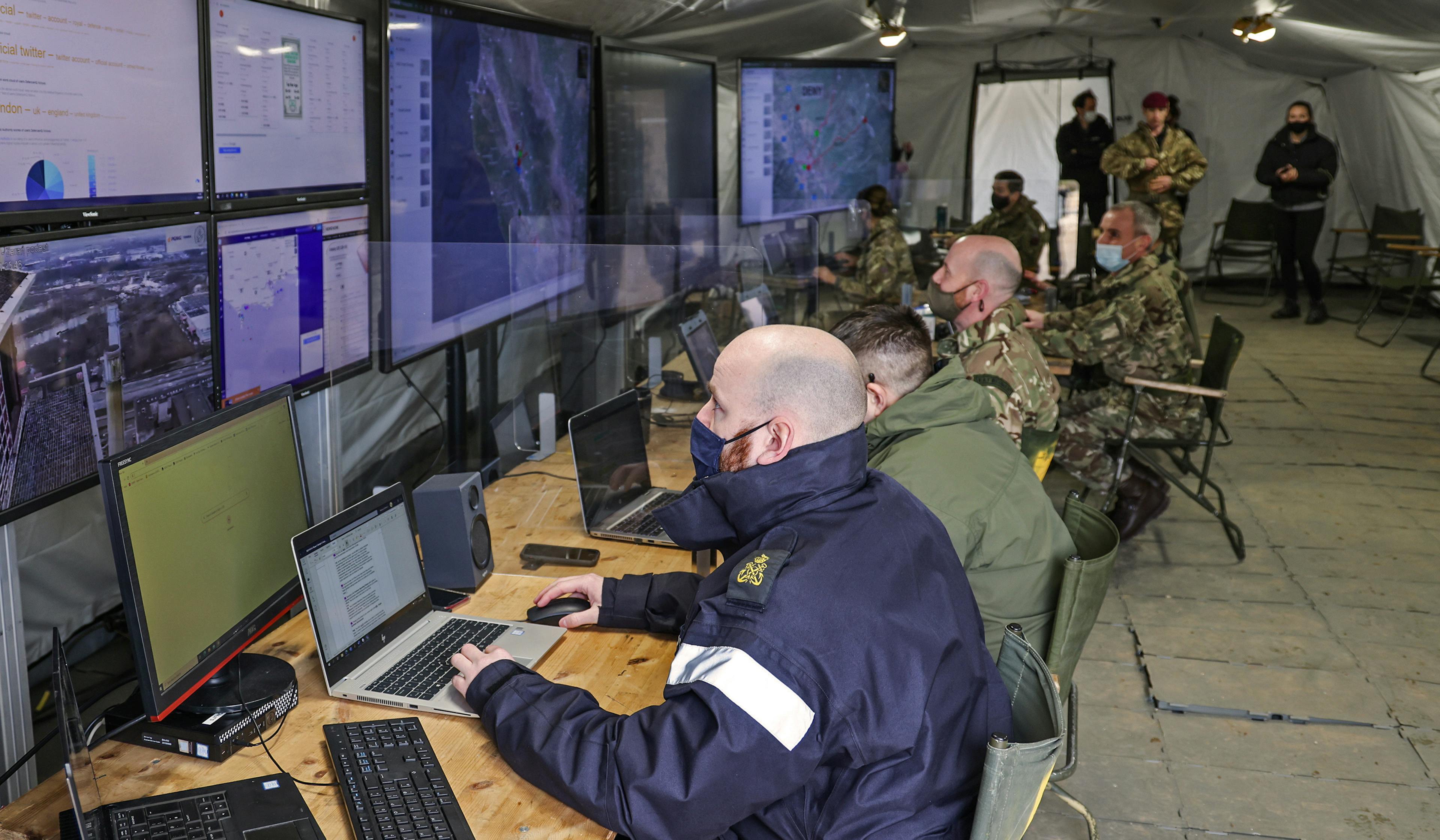 Room of military men on computers.