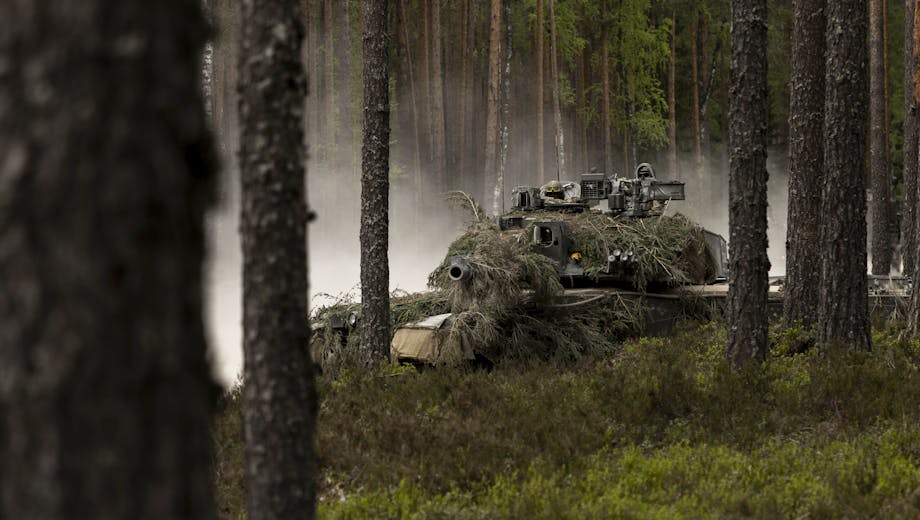 A tank camouflaged in a forest.