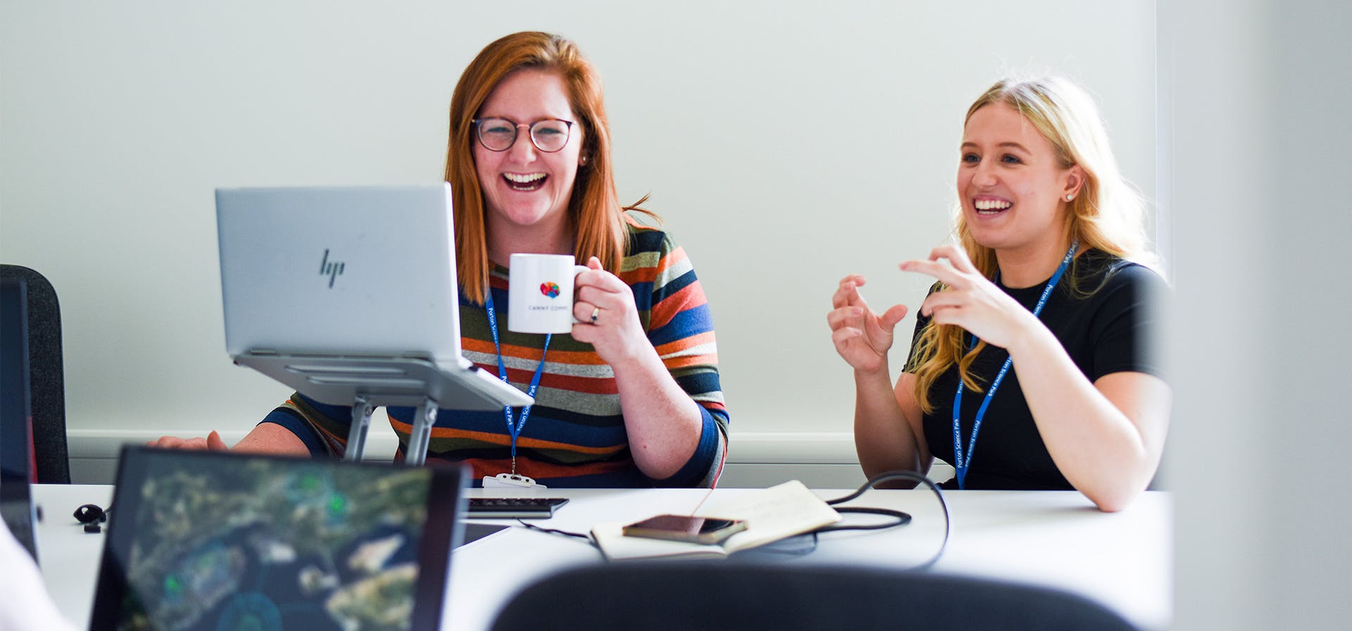 Two Canny Comms team members smiling.