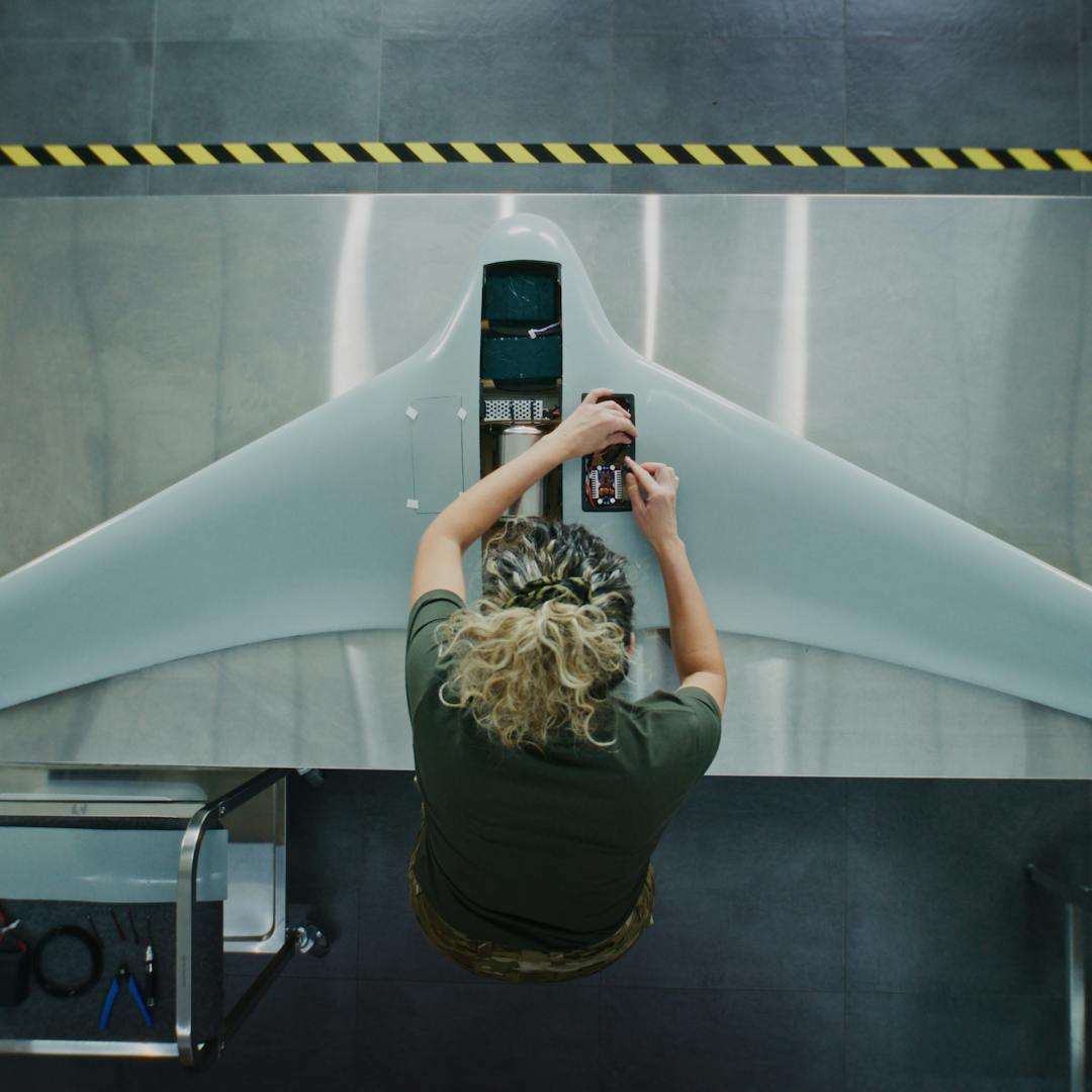 Lady leading over drone on manufacturing line