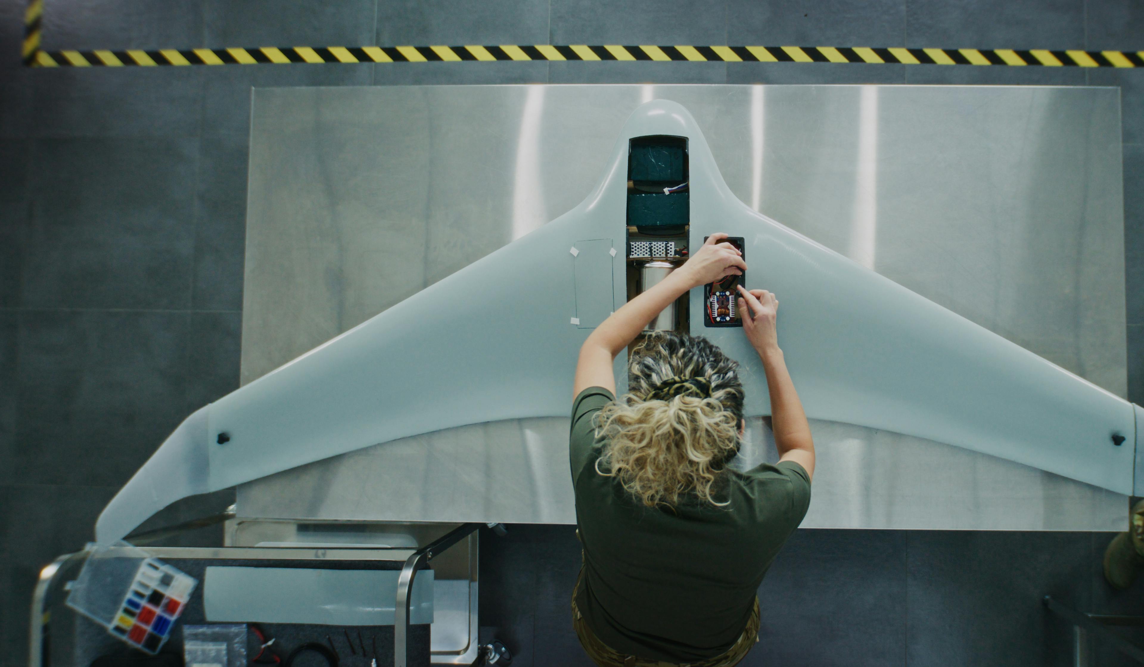 Lady leading over drone on manufacturing line