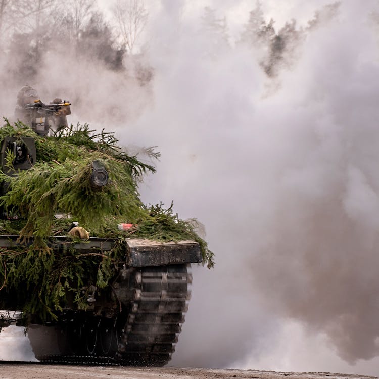 A tank driving through smoke.