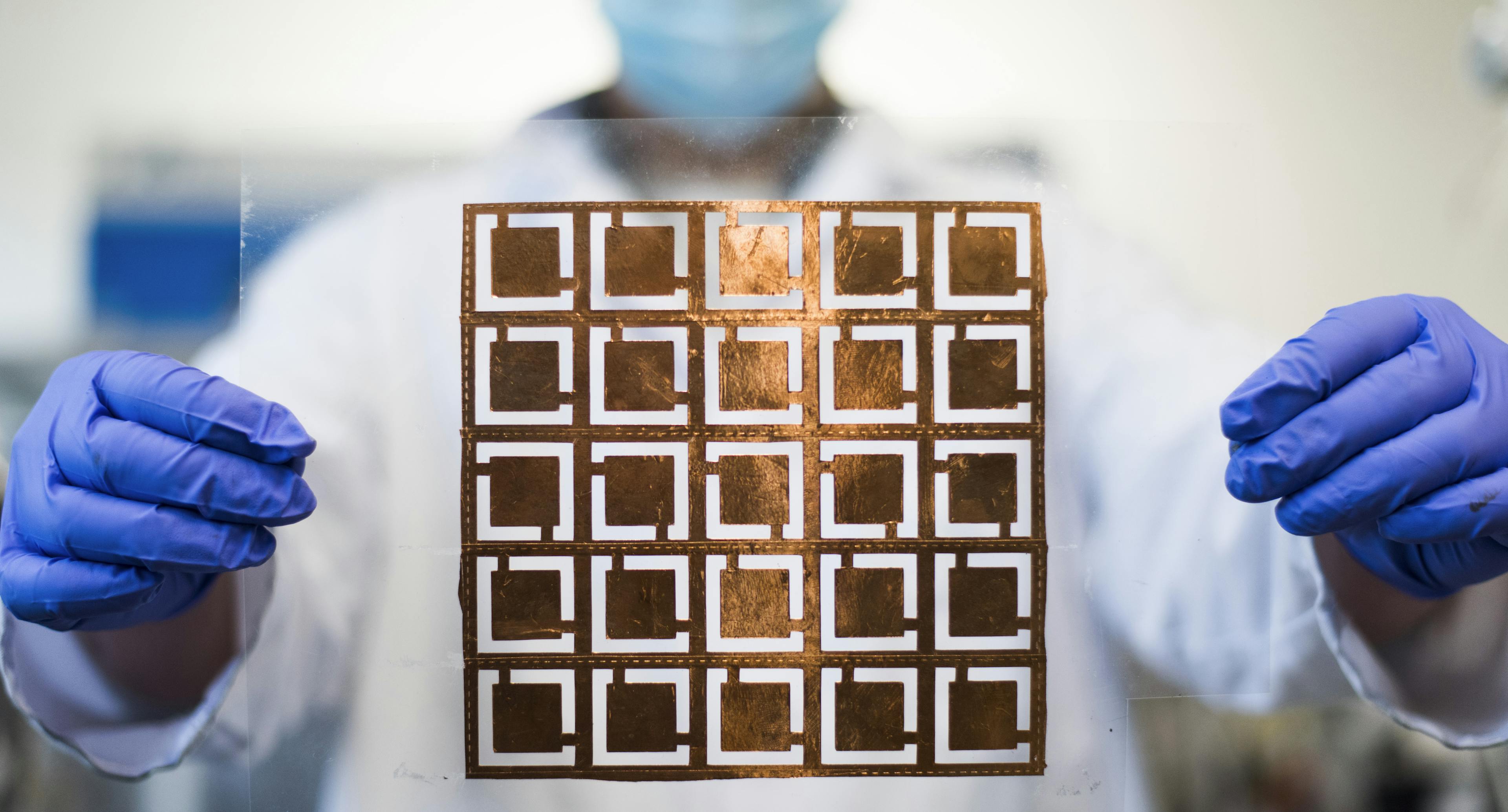 Someone holding a sheet of nano circuits.