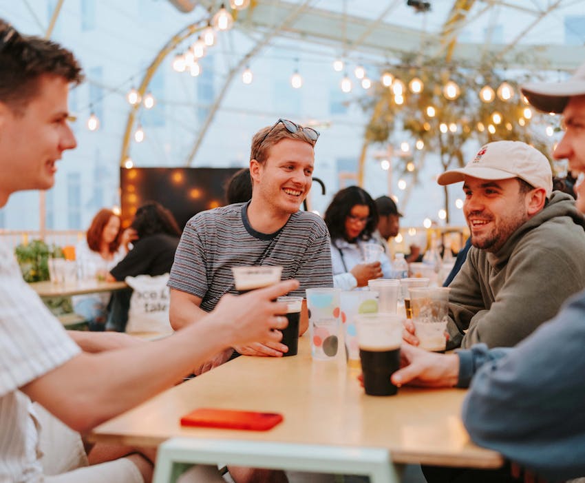 group of men drinking pints of Guinness and having a laugh together