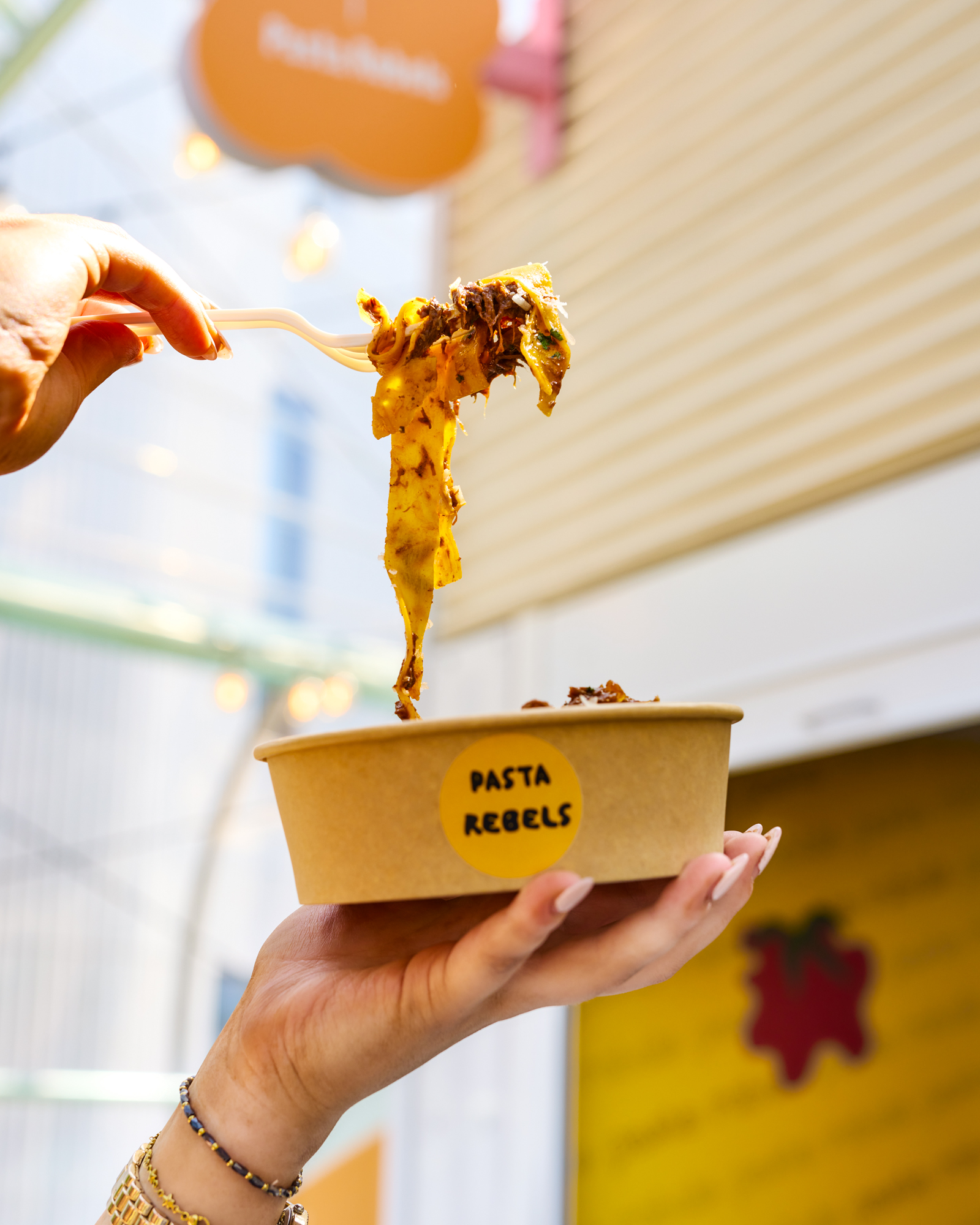 someone holding up a bowl of pasta and pulling it apart by pasta rebels