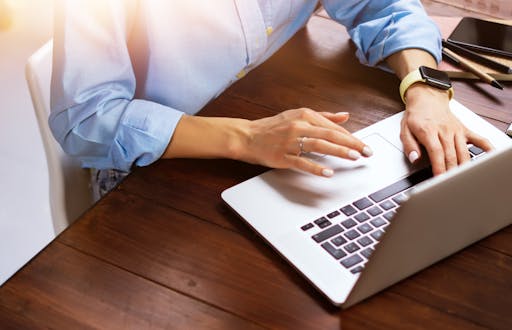 Woman typing on a laptop computer.
