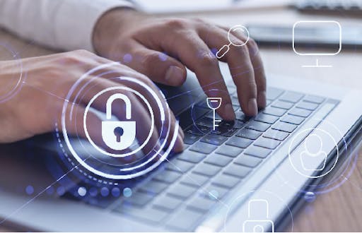 Person typing on a lap top keyboard with a padlock symbol in the middle of the image.